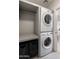 Bright laundry room featuring a stacked washer and dryer and shelving unit at 5505 E Mclellan Rd # 111, Mesa, AZ 85205