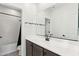 Bright bathroom featuring a shower and tub combination, and a large mirror above the vanity at 6641 N Desert Shadow Ln, Phoenix, AZ 85014