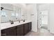 Bright bathroom with a double sink vanity, tiled floor, and a large mirror at 6641 N Desert Shadow Ln, Phoenix, AZ 85014