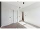 Bright bedroom with neutral carpet, ceiling fan, and closet with double doors at 6641 N Desert Shadow Ln, Phoenix, AZ 85014