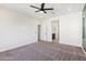 Spacious bedroom with neutral carpet, a ceiling fan, and easy access to an en-suite bath at 6641 N Desert Shadow Ln, Phoenix, AZ 85014