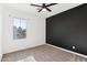 Bedroom featuring a window view, neutral carpet, and dark accent wall at 6641 N Desert Shadow Ln, Phoenix, AZ 85014