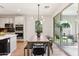 Open-concept dining space with modern lighting and access to a kitchen and outdoor patio at 6641 N Desert Shadow Ln, Phoenix, AZ 85014
