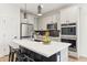 Modern kitchen with white cabinets, a black backsplash, stainless appliances and an island with barstool seating at 6641 N Desert Shadow Ln, Phoenix, AZ 85014