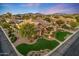 Aerial view of a beautifully landscaped home with mountain views, pristine lawn, and elegant design at 6918 E Ivyglen St, Mesa, AZ 85207