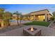 Inviting backyard with a pool, lush landscaping, fire pit, and covered patio, ideal for outdoor entertaining at 6918 E Ivyglen St, Mesa, AZ 85207