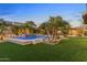 Picturesque backyard with a captivating pool, ambient lighting, and tropical landscaping creating an enchanting retreat at 6918 E Ivyglen St, Mesa, AZ 85207