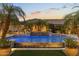 Serene backyard featuring a stunning pool with water features, ambient lighting, and swaying palm trees at 6918 E Ivyglen St, Mesa, AZ 85207