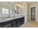 Double sink bathroom vanity featuring dark cabinetry, light countertops, decorative mirrors, and access to the closet at 6918 E Ivyglen St, Mesa, AZ 85207