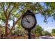 Community clock tower with classic roman numerals mounted near a tree and brick wall at 6918 E Ivyglen St, Mesa, AZ 85207
