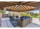 Comfortable covered patio featuring wicker seating, ceiling fan, and outdoor TV, perfect for relaxation at 6918 E Ivyglen St, Mesa, AZ 85207