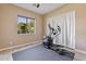 Bright exercise room with elliptical machine and window view to outdoor landscaping at 6918 E Ivyglen St, Mesa, AZ 85207