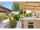 Exterior view showcasing covered patio, outdoor kitchen, and hot tub, blending seamlessly with the home's design at 6918 E Ivyglen St, Mesa, AZ 85207