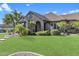 Charming home with manicured lawn, lush landscaping, and a stone archway entrance at 6918 E Ivyglen St, Mesa, AZ 85207