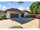 Three car garage with brick paved driveway and well-maintained landscaping at 6918 E Ivyglen St, Mesa, AZ 85207