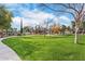 Lush green community lawn with playground, tall trees, and walking path at 6918 E Ivyglen St, Mesa, AZ 85207