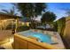Inviting hot tub surrounded by lush greenery and serene landscaping in the backyard at 6918 E Ivyglen St, Mesa, AZ 85207