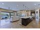 Open kitchen with stainless appliances, large island, and backyard views to create a modern, airy feel at 6918 E Ivyglen St, Mesa, AZ 85207