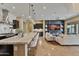Open-concept kitchen flows into the living room, featuring an island with seating, modern appliances, and cozy fireplace at 6918 E Ivyglen St, Mesa, AZ 85207