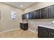 Functional laundry room with ample cabinet storage, sink, and tiled floors at 6918 E Ivyglen St, Mesa, AZ 85207