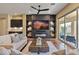 Cozy living room featuring a fireplace, custom built-ins, wood floors, and sliding glass doors to the backyard at 6918 E Ivyglen St, Mesa, AZ 85207