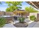 A well-equipped outdoor kitchen and bar area featuring stone accents, a grill, and a relaxing hot tub at 6918 E Ivyglen St, Mesa, AZ 85207