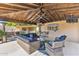 Cozy outdoor seating arrangement with TV, outdoor kitchen, and hot tub, providing a relaxing and entertainment space at 6918 E Ivyglen St, Mesa, AZ 85207