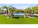Beautiful backyard pool with lush landscaping and tropical palm trees, creating a serene oasis for relaxation and enjoyment at 6918 E Ivyglen St, Mesa, AZ 85207