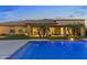 Stunning backyard with a bright blue pool, palm trees, and a covered patio perfect for entertaining at 6918 E Ivyglen St, Mesa, AZ 85207