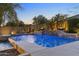 Beautiful pool area with water feature, lush landscaping, and ambient lighting, creating a serene backyard retreat at 6918 E Ivyglen St, Mesa, AZ 85207
