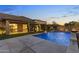 Beautiful backyard with a sparkling blue pool, stone patio, and meticulously landscaped grounds at 6918 E Ivyglen St, Mesa, AZ 85207