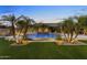 Stunning pool with lush tropical plants and ambient lighting, creating a magical outdoor oasis at 6918 E Ivyglen St, Mesa, AZ 85207