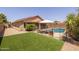 Fenced backyard featuring artificial grass and swimming pool with safety fence at 7701 E Portobello Ave, Mesa, AZ 85212