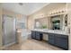 Lovely bathroom with double sinks, a bathtub, and a separate glass-enclosed shower at 7701 E Portobello Ave, Mesa, AZ 85212