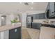 Well-equipped kitchen with stainless steel refrigerator, dark gray cabinetry, and a peninsula with seating at 7701 E Portobello Ave, Mesa, AZ 85212