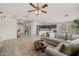Inviting open-concept living room featuring a ceiling fan, light wood floors, and view into the kitchen at 7701 E Portobello Ave, Mesa, AZ 85212