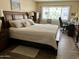 Bright main bedroom featuring a comfortable bed, wood flooring, a window, and a desk area at 7960 E Camelback Rd # 109, Scottsdale, AZ 85251