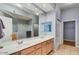 Clean bathroom featuring a double vanity, large mirror, and walk-in shower at 8245 E Bell Rd # 103, Scottsdale, AZ 85260
