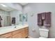 Bathroom with light wood cabinets, large mirror, and shower curtain at 8245 E Bell Rd # 103, Scottsdale, AZ 85260