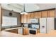 Efficient kitchen with wooden cabinets, white appliances, and natural light at 8245 E Bell Rd # 103, Scottsdale, AZ 85260