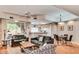Open-concept living room with hardwood floors and modern furnishings with eat-in kitchen in the background at 8245 E Bell Rd # 103, Scottsdale, AZ 85260