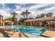 Community pool with lounge chairs, covered seating, and palm trees at 8245 E Bell Rd # 103, Scottsdale, AZ 85260