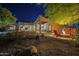 Night view of the backyard showcasing the patio, pool, fire pit, and desert landscaping at 8248 E Arroyo Hondo Rd, Scottsdale, AZ 85266