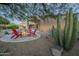 Backyard with stone fire pit, outdoor seating, and beautiful desert plants at 8248 E Arroyo Hondo Rd, Scottsdale, AZ 85266