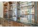 Custom bar area featuring dark granite countertops, wood cabinets, and mirrored shelving for displaying beverages at 8248 E Arroyo Hondo Rd, Scottsdale, AZ 85266