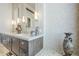 Elegant bathroom featuring a double vanity, decorative vases, and tiled walls at 8248 E Arroyo Hondo Rd, Scottsdale, AZ 85266