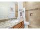 Bathroom features a granite vanity, large mirror, tiled walls, and glass shower doors at 8248 E Arroyo Hondo Rd, Scottsdale, AZ 85266