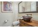 Powder room with copper vessel sink, ornate mirror, and traditional fixtures at 8248 E Arroyo Hondo Rd, Scottsdale, AZ 85266