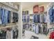 This organized walk-in closet has ample shelving and storage with a dark vanity in the center at 8248 E Arroyo Hondo Rd, Scottsdale, AZ 85266