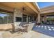 An outdoor covered patio with comfortable lounge chairs, an outdoor television and a desert landscape view at 8248 E Arroyo Hondo Rd, Scottsdale, AZ 85266